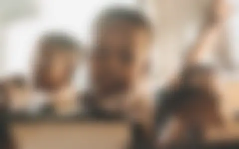 Fotografía difuminada de un niño en un bus, sin rostro nítido